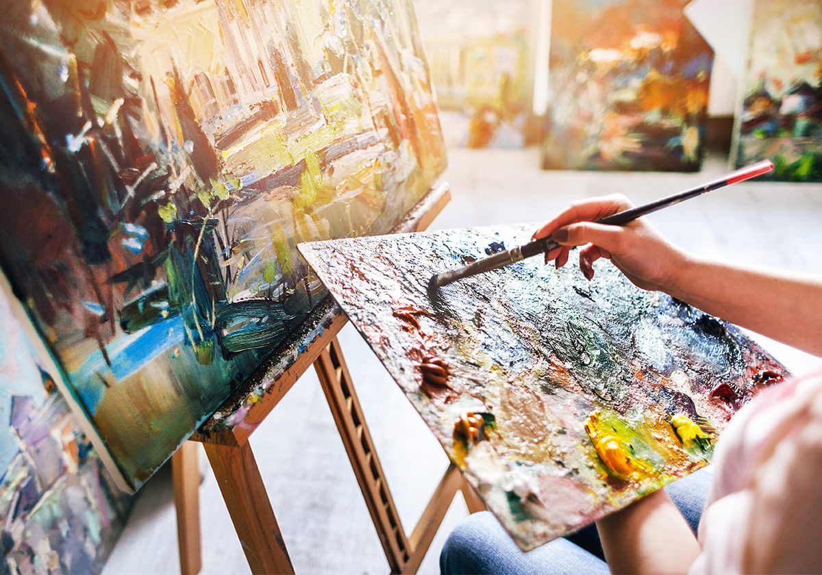 An artist painting at an easel
